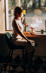 portrait of an adult pretty blonde woman in an elegant suit in a cafe