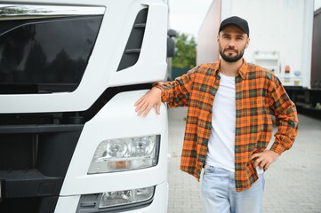 Portrait of young bearded trucker standing by his truck vehicle. Transportation service. Truck...