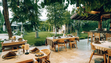 Modern hotel restaurant cafe terrace decorated with a natural stone table and a mix of chairs made...