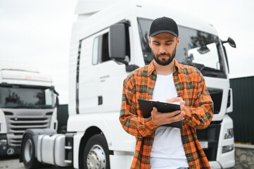 Male driver with clipboard near big truck outdoors