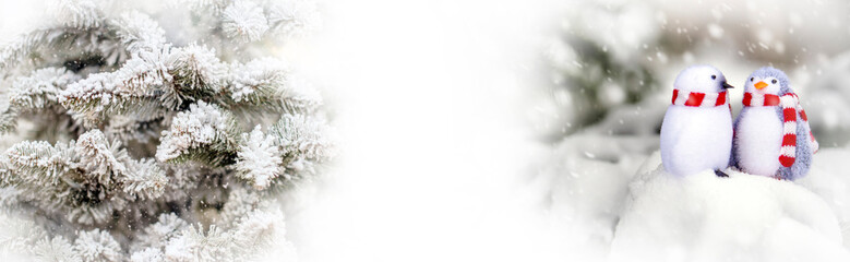 Two decorative penguins sit on the snow
