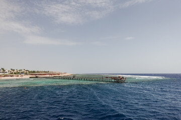 jetty over a coral reef with deep blue water in port ghalib egypt
