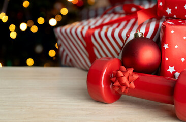 Dumbbell and Christmas gifts. Exercise equipment as gift idea. Healthy fitness holiday season...