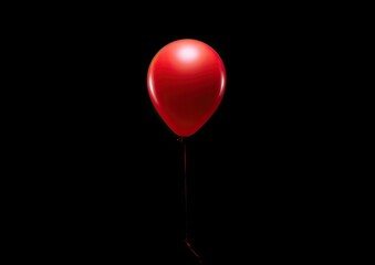 A minimalist photograph of a single red balloon floating against a solid black background. The