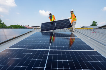 Men technicians carrying photovoltaic solar moduls on roof of factory on the morning. Installing a...