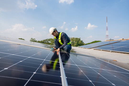 Engineer service check installation solar cell on the roof of factory. Silhouette technician inspection and repair solar cell on the roof of factory. Technology solar energy renewable.