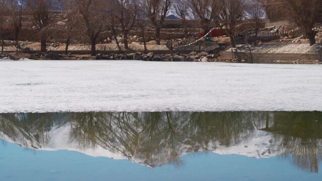 Reflection of snow covered Himalayan mountain in the water of the Nako lake during the winter season at Nako village on the way to Spiti Valley in Himachal Pradesh, India. Reflection of Himalayas. 