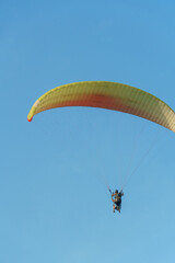 Paragliding in the sky over the sea. The concept of parachute flight. Tandem skydiver pilot and...