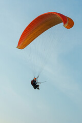 Paragliding in the sky over the sea. The concept of parachute flight. Tandem skydiver pilot and...