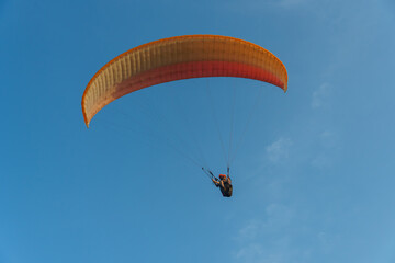 Paragliding in the sky over the sea. The concept of parachute flight. Tandem skydiver pilot and...