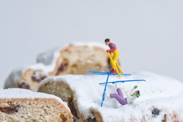 Skier on a Christmas cake, miniature figures scene with the theme, sports accident during the Christmas holidays - obrazy, fototapety, plakaty