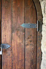 stone wall with an old wooden door with lock