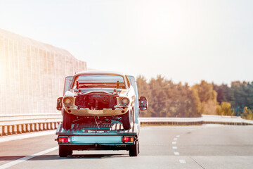 A Retro Car in Need of Repair After a Highway Collision. A Tow Truck Service Providing Emergency...