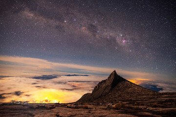 Mount Kinabalu peak with milky way galaxy with stars on a night sky background.on Mount Lowes...