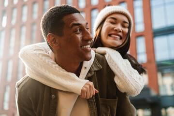 Smiling couple hugging while standing at city street