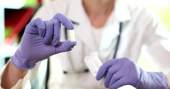 Doctor hands in gloves holds medical candles and vaginal pills. Treatment of prostatitis hemorrhoids and venereal diseases
