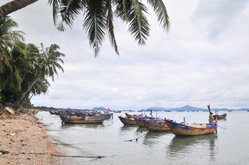 Seascape with boats in the distance and coastline with trash and debris