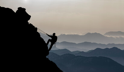 magnificent view of mountain ranges and man rock climbing alone