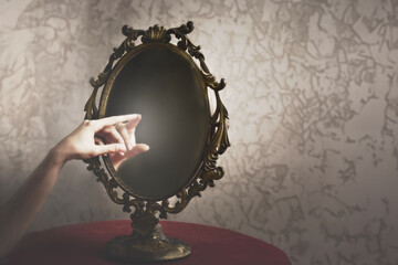 a person's hand touches his hand in the reflection of a mirror, abstract concept