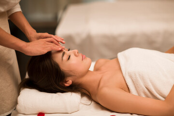 Young woman receiving facial massage at spa center