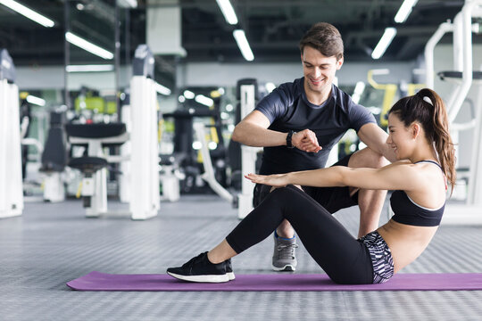 Young woman working with trainer at gym