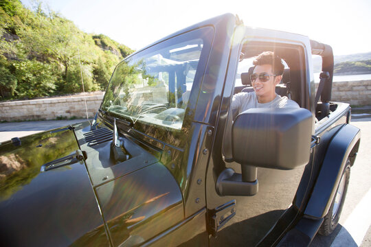 Happy young man driving a jeep