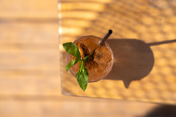 A glass of signature cocktail decorated with Crispy Coconut Roll ( thai dessert ) ,black seasame...
