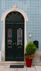 Residential home front door surrounded by traditional Portuguese tiles, Alcobaca, Portugal - 691925016