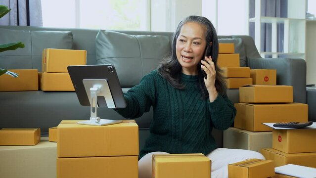 Startup small business entrepreneur or freelance using a laptop with box, checking orders from customers, matron runs an e-commerce business on websites and social media. 