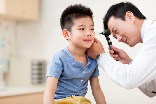 Doctor examining boy's ears