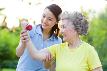 Senior woman exercising with dumbbell in nursing home