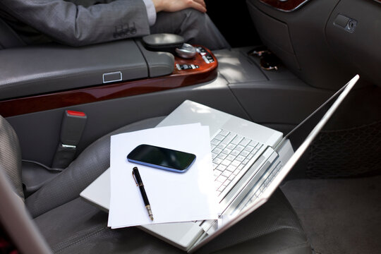 Laptop and mobile phone on car seat