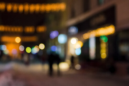 city street at christmas holidays night. blurred festive urban background with bokeh effect