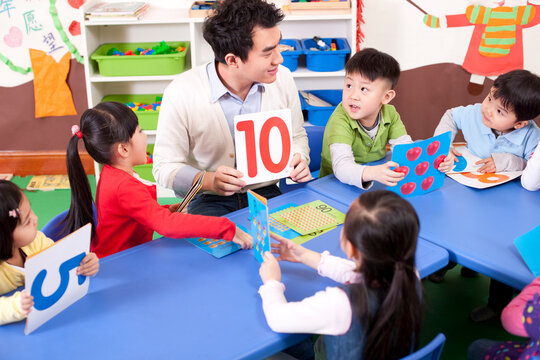 Kindergarten teacher teaching children maths