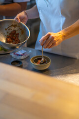 chef plating food in plate while working in commercial kitchen