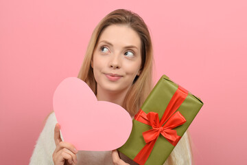 Obraz na płótnie Canvas cute woman holding a gift box on valentine's day