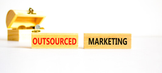 Outsourced marketing symbol. Concept words Outsourced marketing on beautiful wooden blocks....