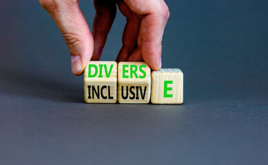 Diverse and inclusive symbol. Concept word Diverse and Inclusive on wooden cubes. Beautiful grey table grey background. Businessman hand. Business diverse and inclusive concept. Copy space.