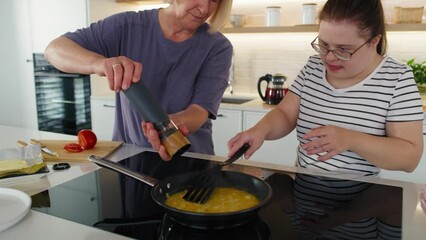 Down syndrome woman helping her mother in preparing breakfast. Shot with RED helium camera in 8K.    