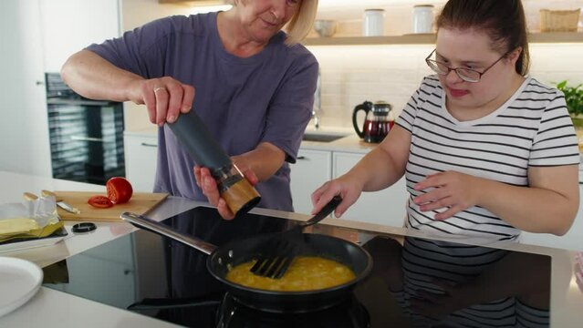 Down syndrome woman helping her mother in preparing breakfast. Shot with RED helium camera in 8K.    