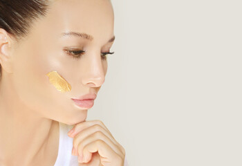 woman applying serum, lotion to her face