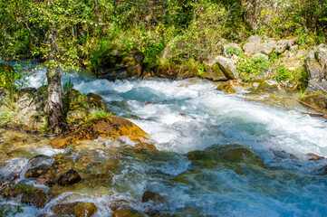 Naklejka na ściany i meble Immerse yourself in the soothing sounds of a mountain stream. Find peace and relaxation in the mesmerizing dance of water and stones. Experience the charm of nature and let your stress fade away