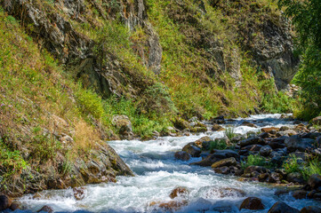 Fototapeta na wymiar Experience the soothing beauty of a mountain stream. Rejuvenate your soul with the soothing sight and sound of water flowing over ancient rocks. Refresh your senses with clear sounds