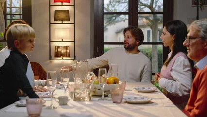 A young married couple announces to the whole family that they will soon have a child.
Beautiful excited mother shows ultrasound of newborn baby.
The family hugs them.