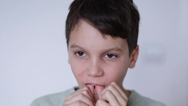 A boy puts on retainers, on a white background. Concept of correcting crooked teeth and occlusion in a child, installing a jaw expander.