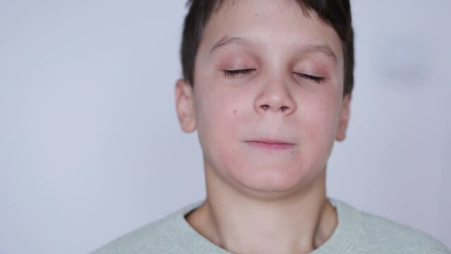 A boy puts on retainers, on a white background. Concept of correcting crooked teeth and occlusion in a child, installing a jaw expander.
