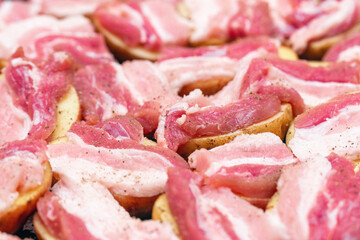 Raw potatoes with bacon, prepared for baking in the oven