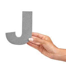Hand of woman, capital letter J and presentation of consonant isolated on white background. Character, font and palm with English alphabet typeface for communication, reading and writing in studio.