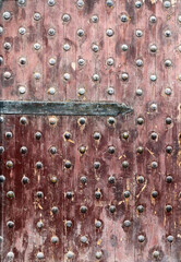Detail of old wooden gate leaf part. Ancient wood door with metal rivets in Qaitbay Citadel, Alexandria, Egypt