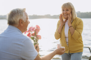 Senior Gentleman Making Proposal To Happy Excited Lady Outdoors